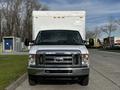 A 2013 Ford Econoline van with a white box truck attached in front view