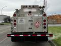 A 2018 Ford F-550 fuel truck with a silver tank labeled flammable and hazard symbols on its rear side