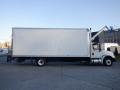 A 2014 International Durastar box truck with a white cargo area and a black chassis viewed from the side