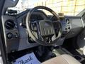 Interior view of a 2011 Ford F-350 SD showing the steering wheel dashboard and control panel with a thank you note on the floor