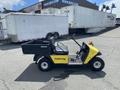 A 1999 Ez-go Industrial electric vehicle with a yellow front and black cargo bed parked on a concrete surface. It features a single seat and compact design for utility use