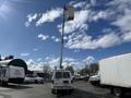 A 2008 Ford Econoline equipped with a tall aerial lift and bucket attached to its roof, positioned in a vehicle lot