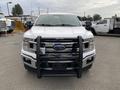 2018 Ford F-150 in white with a front grille guard and front-mounted equipment creating a robust appearance
