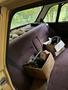 A vintage 1978 Volvo 244 with a maroon interior featuring a back seat filled with cardboard boxes and a few miscellaneous items