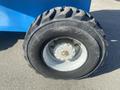 Close-up of a 1997 Genie S-65 4X4 tire with a rugged tread pattern and metallic wheel hub featuring multiple bolt holes
