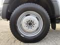 Close-up of a 2020 Ford F-550 wheel showcasing a silver alloy rim with lug nuts and a robust black tire featuring an all-terrain tread pattern