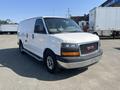 A 2016 GMC Savana van in white with a front grille featuring the GMC logo and orange headlights