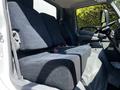The interior of a 2020 Hino 155 showing the driver's seat and passenger seats upholstered in dark fabric with reclining adjustments