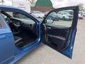 A blue 2022 Dodge Charger with the driver's side door open showing the interior features and seating