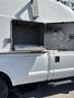 A white 2014 Ford F-350 SD with an open storage compartment on its side showing shelves and metal paneling