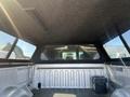 Interior view of the bed of a 2014 Ford F-150 with a covered top and black lining