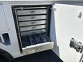 A metal storage compartment with multiple drawers pulled out revealing tools and hardware inside a 2016 Ford F-550