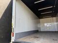 Interior view of a 2024 Isuzu FVR truck showing a spacious empty cargo area with wooden flooring and plain white walls