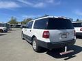 A white 2013 Ford Expedition parked with a black rear and a chrome hitch receiver visible on the back
