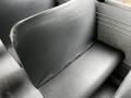 A row of black vinyl seats from a 2015 Spartan School Bus arranged in a row with visible stitching and a textured surface