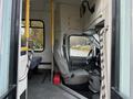 Interior view of a 2009 Ford Econoline showing the driver's seat and passenger area with gray upholstery and yellow handrails