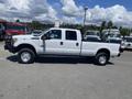 A white 2016 Ford F-350 Super Duty pickup truck with a crew cab and an open truck bed, featuring chrome wheels and a sturdy build