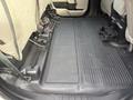 The interior floor of a 2020 Ford F-550 featuring rubber flooring and lack of seats in the back area with visible seat anchors and a cup holder console