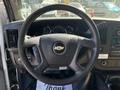 The interior of a 2017 Chevrolet Express featuring a black steering wheel with a centered Chevrolet logo and various controls on the side
