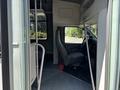 Interior view of a 2020 Chevrolet Express showing the driver's seat and dashboard with access to the passenger area and steps visible