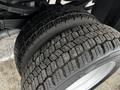 Close-up of a large, rugged tire mounted on the wheel of a 2008 Ford F-450 SD with deep treads designed for enhanced traction and durability