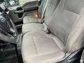 The image shows the front seats of a 2018 Ford F-150 with fabric upholstery and seat belts visible