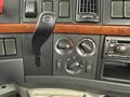 Control panel of a 2012 Volvo VNL featuring climate controls and a gear shift lever with various knobs for air conditioning and ventilation settings