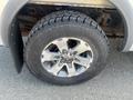 A close-up of a 2014 Ford F-150 tire featuring an aluminum alloy wheel and rugged all-terrain tread design