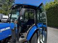 A blue 2018 New Holland Boomer 45 tractor with an open door and visible controls inside the cabin