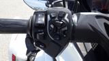 Close-up of the control grip of a 2013 Can-Am Spyder showcasing buttons for headlights and various modes