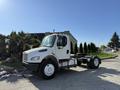 A white 2003 Freightliner M2 106 truck with a cab and chassis visible in the foreground