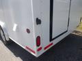 A rear view of a white 2004 Royal 18 Foot Office Trailer showing the taillights and a black door handle