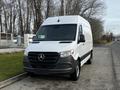 A white 2022 Mercedes-Benz Sprinter van with a black grille parked on a street featuring a tall front and large cargo space