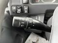 Close-up of a multifunction control stalk for a 2022 Isuzu NPR featuring settings for headlights and cruise control with various markings and buttons