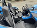 Interior of a 2020 Polaris Slingshot showing two black seats with seatbelts a steering wheel and a central console with controls and cupholders