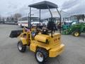 A yellow 2024 AGT KRW 23 Mini loader with a black canopy and front bucket attachment, designed for small-scale earth moving and construction tasks