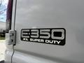 A close-up of a 2004 Ford Econoline E-350 XL Super Duty badge affixed to the rear of the vehicle