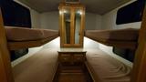 Interior view of a 1998 Fleetwood Tioga Bunkbed featuring two upper bunks with soft cushions and a central storage unit with a mirror above