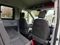 Interior view of a 2019 Ford Transit showing two front seats and a console with a clean design and fabric upholstery