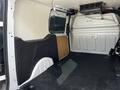 Interior view of a 2016 Ford Transit Connect showing the cargo space with a black side panel and a rear wall with ventilation grilles