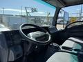 Interior view of a 2013 Isuzu NPR showing the driver's seat steering wheel and dashboard controls