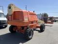 2008 JLG Boom Lift with orange body and extended arm positioned for elevation equipped with large wheels and a platform at the end of the arm