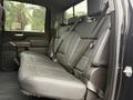 The back seat of a 2022 GMC Sierra 3500HD featuring a spacious leather bench with seat belts and a modern design
