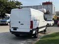 A white 2021 Mercedes-Benz Sprinter van viewed from the rear with black detailing on the lower section and a sliding side door