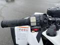Close-up of the handlebar controls of a 2017 Polaris Scrambler showing the throttle grip and engine toggle switch