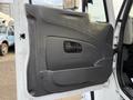 A gray door panel of a 2013 International Durastar 4300 featuring a handle and a textured surface