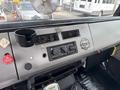 Interior dashboard of a 1998 Freightliner FL80 featuring air conditioning controls a cup holder and a sticker reading Forge Future