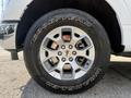 Close-up of a silver wheel on a 2021 Ford F-150 featuring a Goodyear Wrangler tire and five-spoke alloy rim