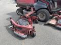 A red Toro Groundsmaster 5910 mowing deck with wheels and mounting brackets laying on the ground