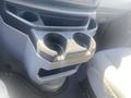 Cup holder console of a 2009 Ford Econoline with two cup slots and a storage compartment below